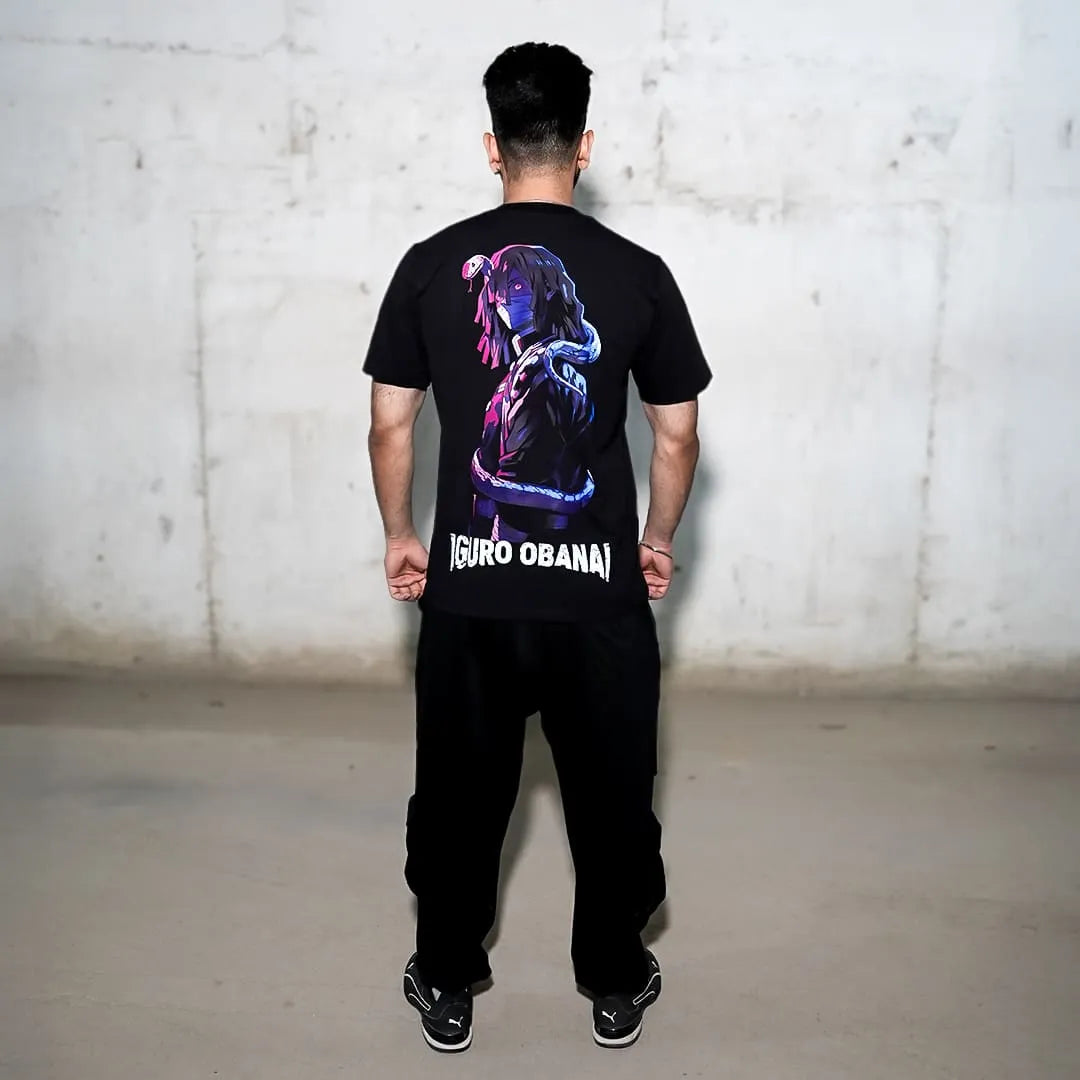 Rear view of model wearing Iguro Obanai black oversized t-shirt with neon anime graphic and bold logo