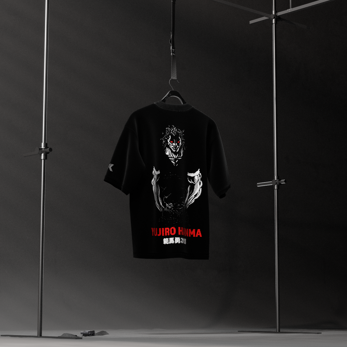 Yujiro Hanma black oversized t-shirt hanging on studio rack showing large back demon face graphic with red logo