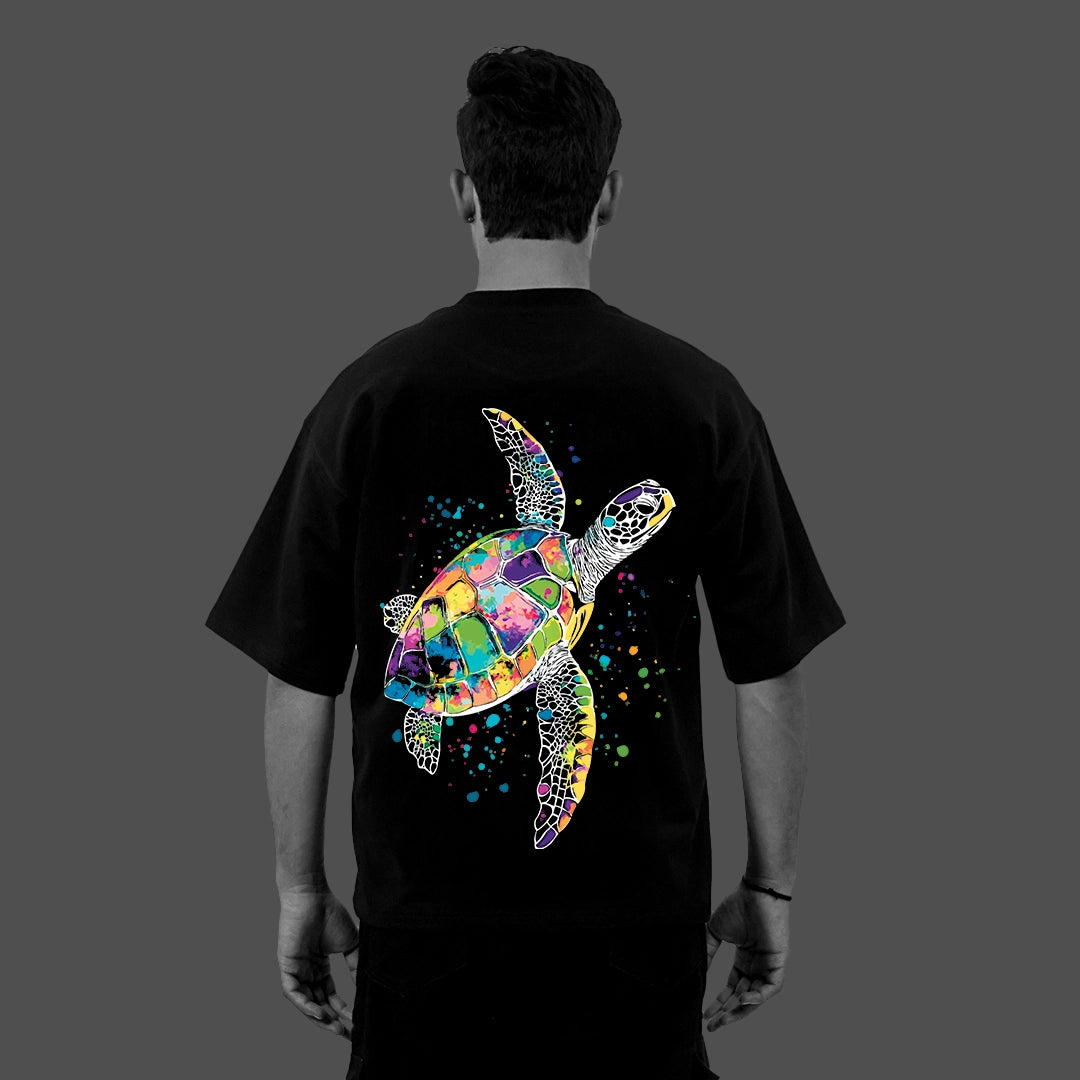 Back view of model wearing Vlack Black black oversized streetwear t-shirt with vibrant multicolor sea turtle graphic
