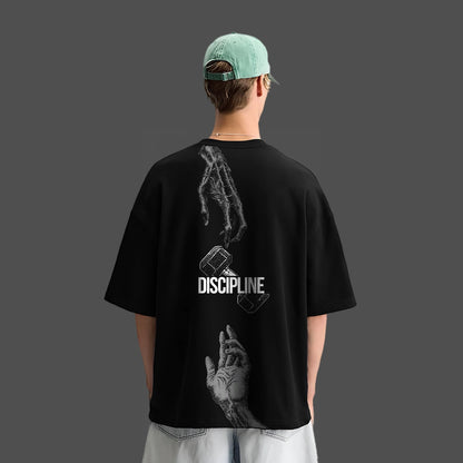 Model wearing a black oversized streetwear t-shirt with graphic design on the back