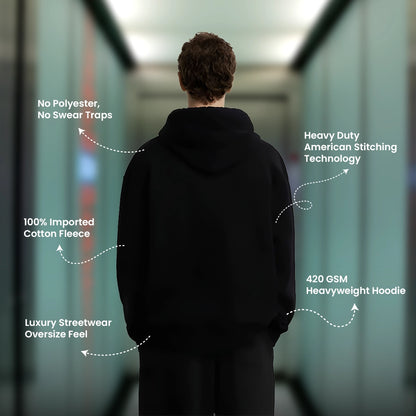 Man wearing an oversized black hoodie featuring 100 percent cotton fleece and heavyweight design