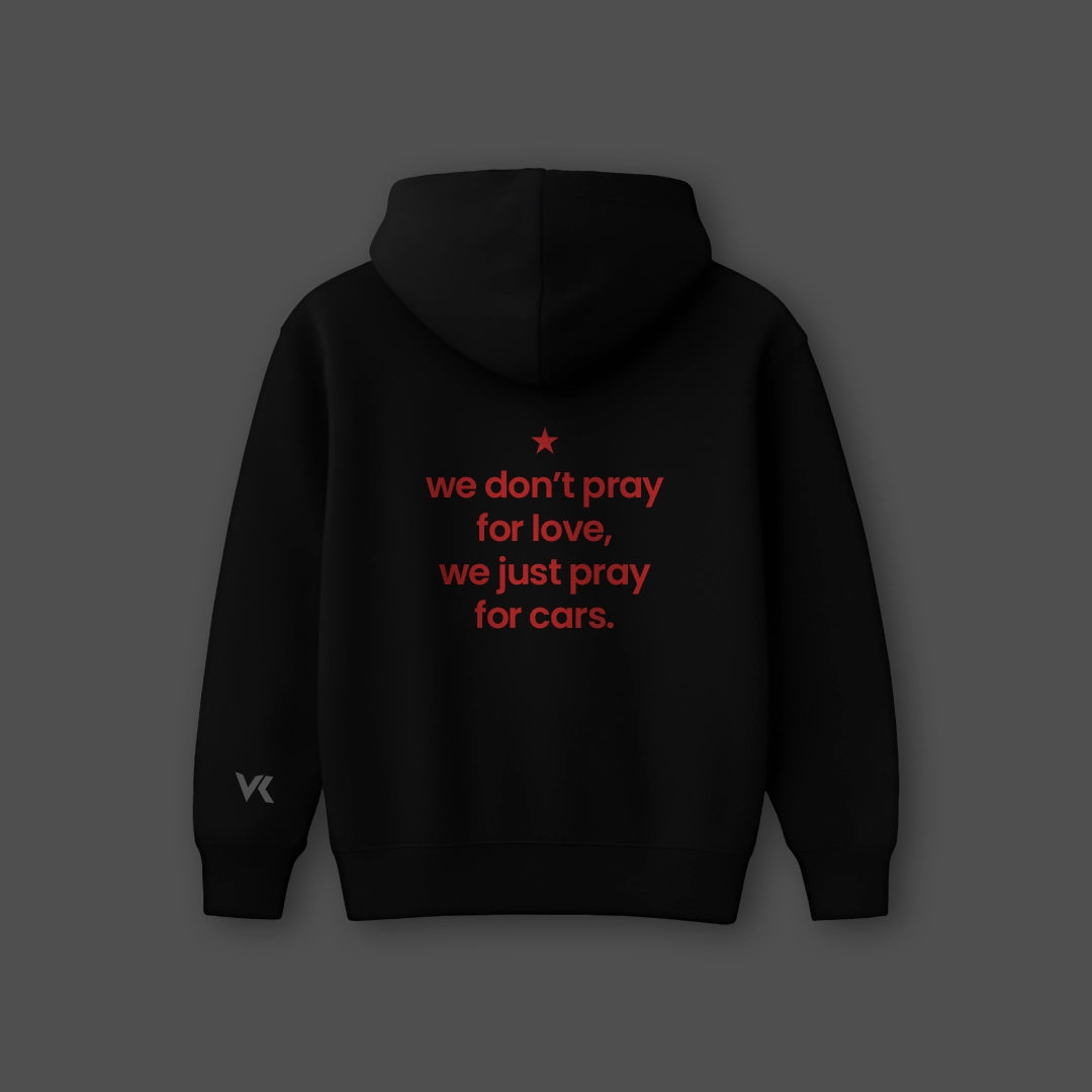 Oversized black hoodie streetwear with red text that reads we don't pray for love, we just pray for cars