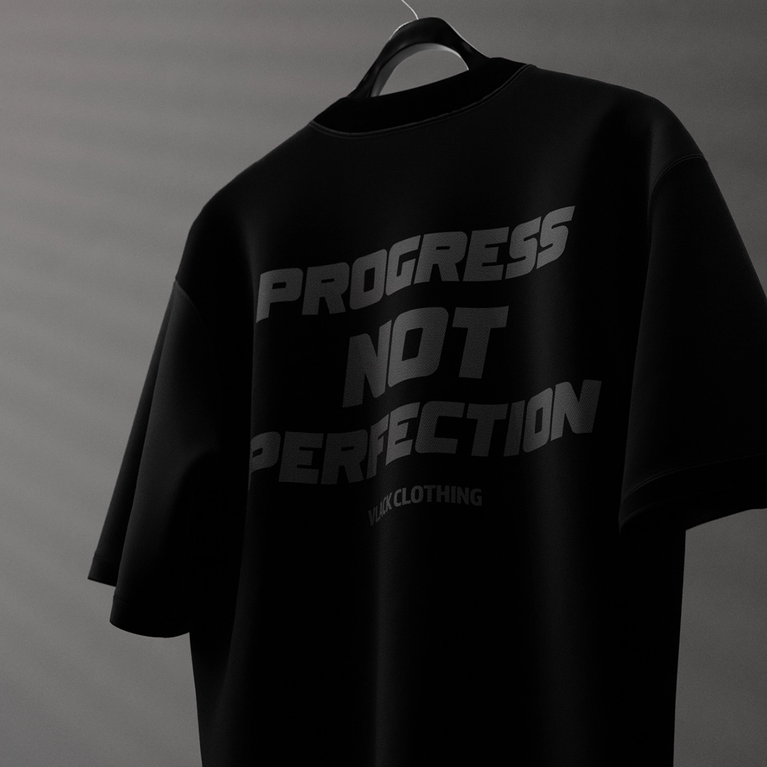 Black oversized streetwear t-shirt with 'Progress Not Perfection' graphic design