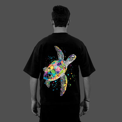 Back view of model wearing Vlack Black black oversized streetwear t-shirt with vibrant multicolor sea turtle graphic