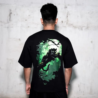 Back view of model wearing Vlack black panther oversize t-shirt with green jungle panther graphic on back